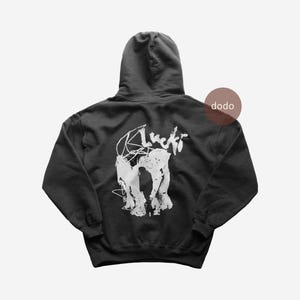 May include: A black hooded sweatshirt with a white graphic design on the back. The design includes the word "Lucki" in a handwritten font and an abstract image. The word "dodo" is printed on the upper right side.