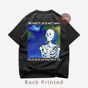Könnte beinhalten: Schwarzes T-Shirt mit einem Skelett-Motiv. Das Design zeigt ein Skelett mit den Worten "BONES" oben und "UNRENDERED" unten. Die Grafik hat einen blauen, grünen und gelben Hintergrund. Die Worte "Back Printed" stehen unten.