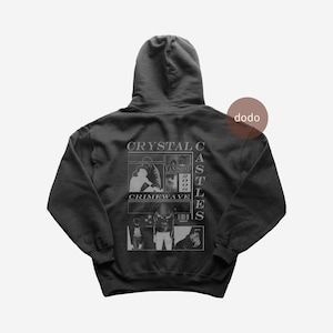 May include: A black hooded sweatshirt with a graphic design on the back. The design includes the text "CRYSTAL C" above a rectangular image with the words "VANISHED 2008" and "CRIMEWAVE". The word "CASTLES" is printed vertically on the right side.