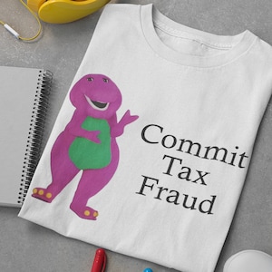 May include: White t-shirt featuring a purple dinosaur character and the text "Commit Tax Fraud".