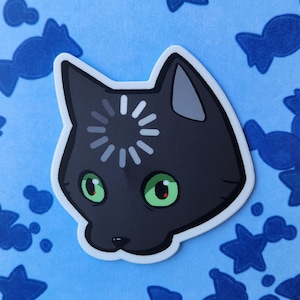 May include: A black cat sticker with a loading symbol on its forehead and green eyes. The sticker is on a blue background with a pattern of blue candy.