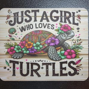 May include: A decorative mousepad with a wooden plank background. The mousepad features a colorful turtle adorned with flowers and the text "JUST A GIRL WHO LOVES TURTLES" in a whimsical font.