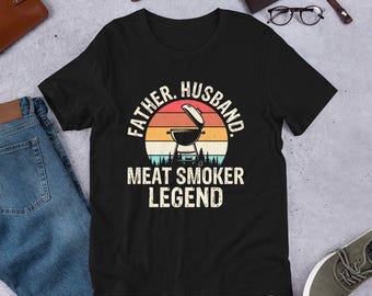 May include: Black t-shirt with a vintage-style graphic of a smoker and the text "Father. Husband. Meat Smoker Legend."