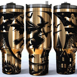 May include: A gold-toned stainless steel tumbler with a black handle and a black lid featuring a straw. The exterior displays a black graphic print of a witch flying on a broomstick, a haunted house, ghosts, bats, and jack-o'-lantern pumpkins.