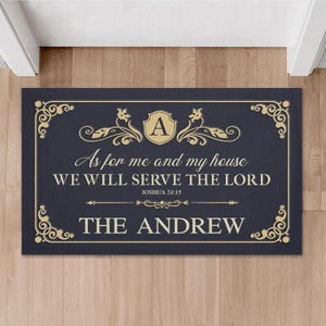 Puede incluir: Una alfombra rectangular azul marino con borde dorado y texto. El texto dice "As for me and my house WE WILL SERVE THE LORD Joshua 24:15 THE ANDREW". Una letra "A" dorada está en un escudo en la parte superior.