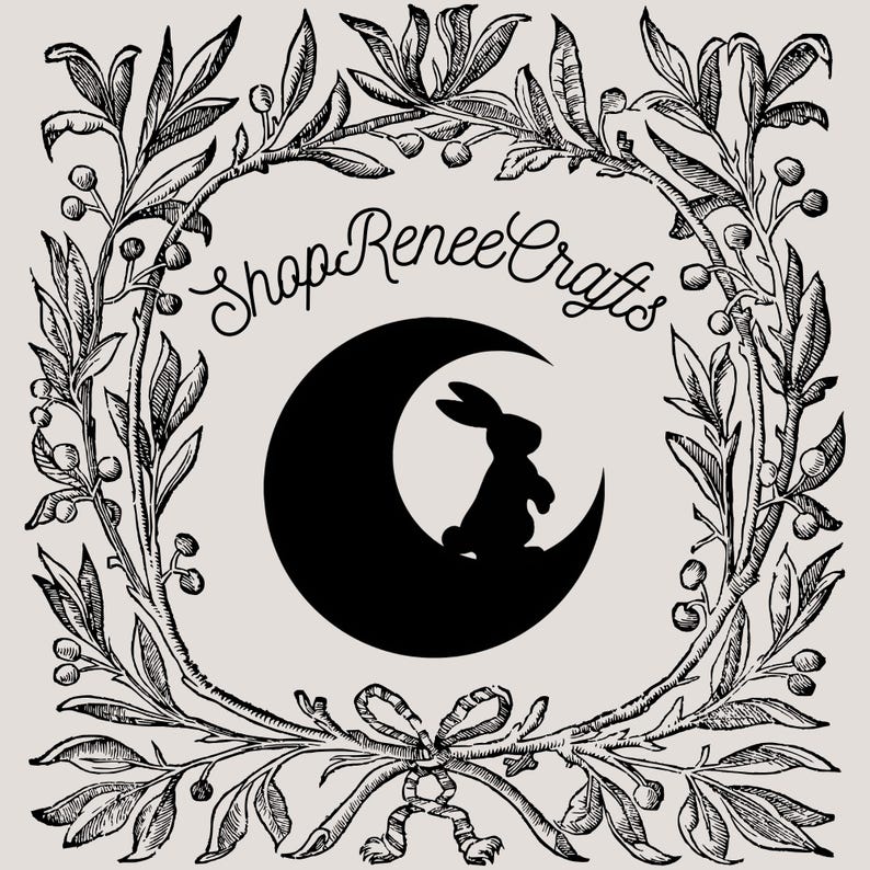 Op de afbeelding: Een logo met een zwart silhouet van een konijn op een halve maan, tegen een lichtbeige achtergrond. De tekst "Shop Renee Crafts" staat in sierlijke letters erboven. Het ontwerp is omlijst door een gedetailleerde bloemenrand.