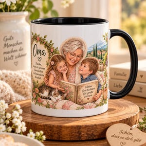 Puede incluir: Una taza de cerámica blanca con asa y borde negros, que presenta una ilustración impresa de una abuela leyendo un libro a una niña y un niño con un gato. El texto dice Oma, Danke, dass du unsere Geschichte so besonders machst, y Kleine Geschichten für große Herzen.