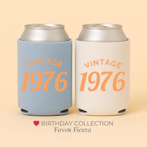 May include: Two can coolers, one light blue and one off-white, each with a silver top and the words "VINTAGE 1976" in orange. The coolers are part of the Birthday Collection.