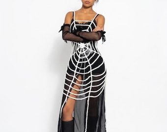 May include: A black sleeveless dress featuring a white spiderweb pattern overlay, thin shoulder straps, and a sheer skirt with a high slit. The outfit includes black sheer arm sleeves with tie details, black sunglasses, and black platform boots.