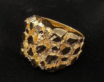 May include: A gold ring with a textured, nugget-like design.