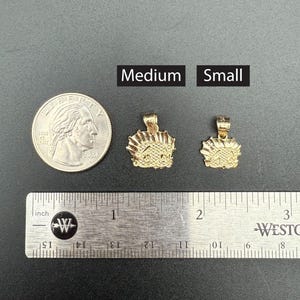 May include: Two gold-colored pendants, one labeled "Medium" and the other labeled "Small", are shown next to a ruler and a US quarter. The pendants are both in the shape of a crown.