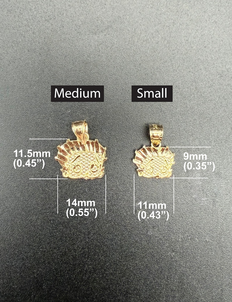May include: Two gold-colored pendants, one larger and one smaller, with a cartoon character design. The larger pendant measures 1.15 inches in height and 0.55 inches in width. The smaller pendant measures 0.35 inches in height and 0.43 inches in width.