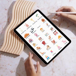May include: A digital tablet screen displaying a grid of colorful icons representing different holidays and events, including Halloween, Carnival, Children's Day, Autumn Begins, and Birthday. Each icon is accompanied by the corresponding holiday or event name.