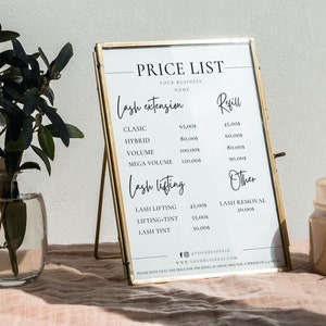 May include: A gold-framed price list for lash extensions and lash lifting services. The list includes prices for classic, hybrid, volume, and mega volume lash extensions, as well as lash lifting, lifting-tint, and lash tint services. A small vase with greenery and a candle are also in the image.