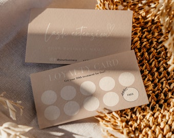 May include: Two tan business cards with the text "Lash extension" and "Your business name". A loyalty card with circles and the text "Get your 10th treatment for free!" is also visible. The cards are on a textured surface.