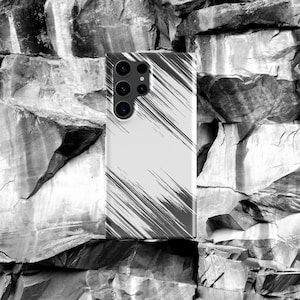 Puede incluir: Una funda para teléfono de color blanco y negro con un diseño abstracto texturizado. La funda tiene una lente de cámara con cuatro círculos negros.