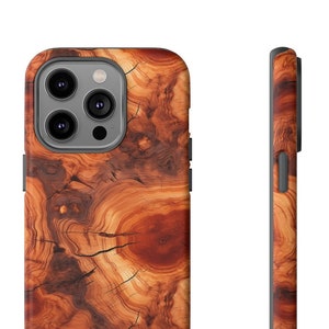 May include: A brown and orange wood grain phone case for an iPhone. The case has a raised camera bump and a black border.