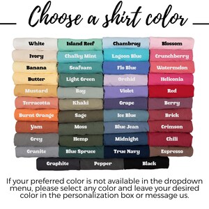 May include: A color chart displaying folded t-shirts in various shades, including white, ivory, yellow, orange, green, blue, purple, pink, red, brown, gray, and black. Each shirt is labeled with its specific color name in white or black text.