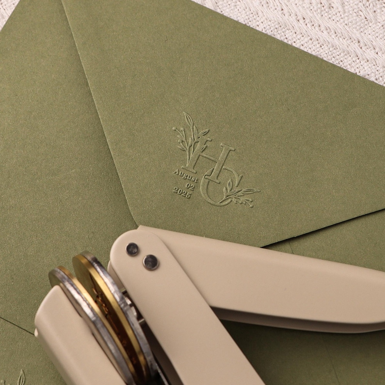 May include: A green envelope with a wax seal featuring the letters "H" and "G" intertwined with floral designs. The date "August 02, 2025" is printed below the monogram.