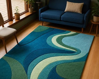 May include: A rectangular area rug featuring a layered, abstract pattern of flowing, curved shapes in various shades of blue, teal, and green. The design consists of deep navy, bright turquoise, light mint, and forest green sections with a textured pile.