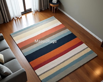 May include: A rectangular area rug with horizontal stripes in various colors, including blue, orange, red, and beige. The rug is placed on a hardwood floor, and the text "MasudRugs" is visible on the rug.