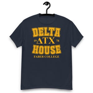 Peut inclure: Un t-shirt bleu marine à manches courtes avec un texte jaune de style universitaire indiquant DELTA HOUSE, les lettres grecques ΔTX, les chiffres 19 et 78, et les mots FABER COLLEGE imprimés au centre sur le devant du vêtement.