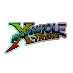 May include: Holographic sticker with the text "WORMHOLE XTREME" in a stylized font. The "X" is yellow and green, the word "WORMHOLE" is teal, and "XTREME" is orange and red. The sticker has a reflective, iridescent finish.