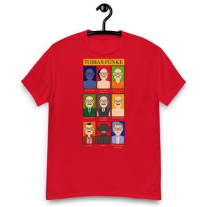 May include: Red t-shirt with a graphic of Tobias Funke from the TV show Arrested Development. The graphic features a grid of nine squares, each containing a different characterization of Tobias Funke, with a caption below each square.