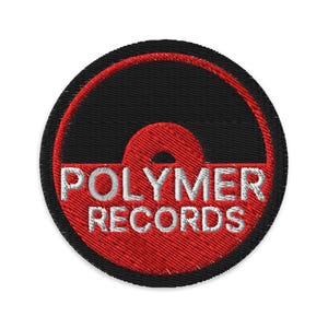 Könnte beinhalten: Gestickter Aufnäher mit einem Vinyl-Schallplatten-Design. Der Aufnäher hat einen schwarzen Hintergrund mit einem roten Innenkreis und einem roten Halbkreis. Die Worte "POLYMER RECORDS" sind weiß gestickt.
