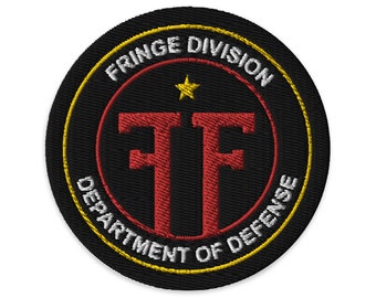 Puede incluir: Un parche bordado negro y dorado con el texto "FRINGE DIVISION DEPARTMENT OF DEFENSE" y un logotipo "FF" rojo con una estrella dorada encima.
