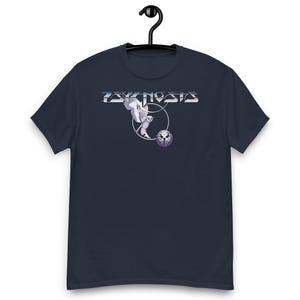 Può includere: Una t-shirt blu navy a maniche corte con una stampa grafica sul petto. Il design include la parola PSYKNOSIS in un carattere argento metallizzato sopra un gufo bianco in volo e un emblema circolare viola con un'illustrazione di un gufo.