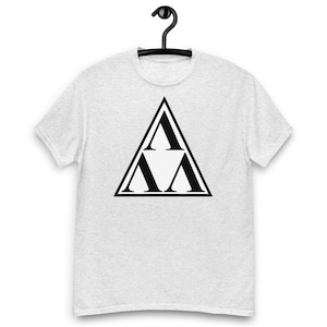 May include: A light heather gray short-sleeve t-shirt featuring a large black graphic centered on the chest. The graphic consists of a bold black triangle outline containing three smaller black capital letter A characters arranged in a triangular formation.
