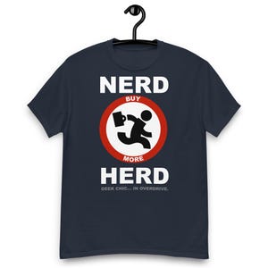 Puede incluir: Camiseta azul marino con las palabras "NERD BUY MORE HERD" en blanco. Un gráfico de un hombre de palitos corriendo con un maletín está dentro de un círculo rojo. El texto "GEEK CHIC... IN OVERDRIVE" está debajo.
