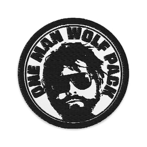 Può includere: Toppa ricamata circolare in bianco e nero con la scritta "ONE MAN WOLF PACK". Raffigura un uomo con occhiali da sole e barba. Adatta per personalizzare abbigliamento.