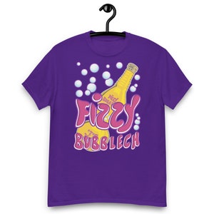 Könnte beinhalten: Lilafarbenes T-Shirt mit einem Aufdruck einer gelben Flasche mit einem rosa Etikett, auf dem "Fizzy Bubbles" und "Bubblech" steht.