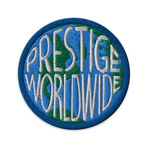 May include: A blue and green embroidered patch with the text "Prestige Worldwide" in white.