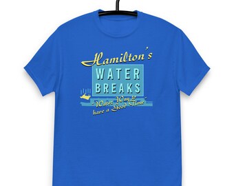 May include: A royal blue t-shirt with a graphic design that says "Hamilton's Water Breaks" in a retro font. The graphic also includes a small boat and the text "Water Way to have a Good Time".