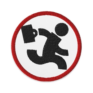Puede incluir: Parche bordado circular con una figura negra corriendo con un maletín y una taza. El diseño está enmarcado por un borde rojo sobre un fondo blanco. El parche tiene una textura, ideal para ropa o bolsos.