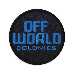 May include: A black and blue embroidered patch with a globe design and the text "OFF WORLD COLONIES".
