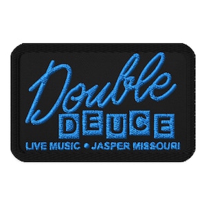 Peut inclure: Écusson brodé noir avec l'inscription "Double Deuce" en bleu, surmontant "Live Music Jasper Missouri". Le patch a une bordure noire et une forme rectangulaire.