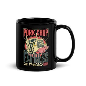 Op de afbeelding: Een zwarte keramische mok met een afbeelding van een witte vrachtwagen en een roze varken. De tekst luidt PORK CHOP EXPRESS, SAN FRANCISCO en JACK BURTON TRUCKING CO. Het ontwerp bevat een rode cirkelvormige achtergrond achter de illustratie.