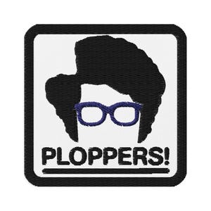 Könnte beinhalten: Gestickter Aufnäher mit einer schwarzen Silhouette einer Person mit dunklem Haar und blauer Brille auf weißem Hintergrund. Das Wort "PLOPPERS!" wird in Schwarz unter der Figur innerhalb eines schwarzen rechteckigen Rahmens angezeigt.