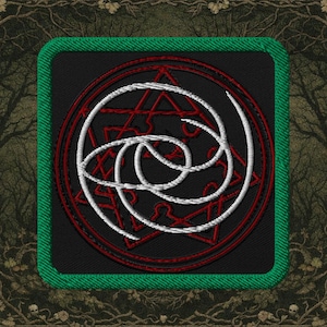 May include: Embroidered patch featuring a complex white and red design on a black background. The design includes a star, circles, and interwoven lines. The patch has a green border and is likely for clothing or accessories.