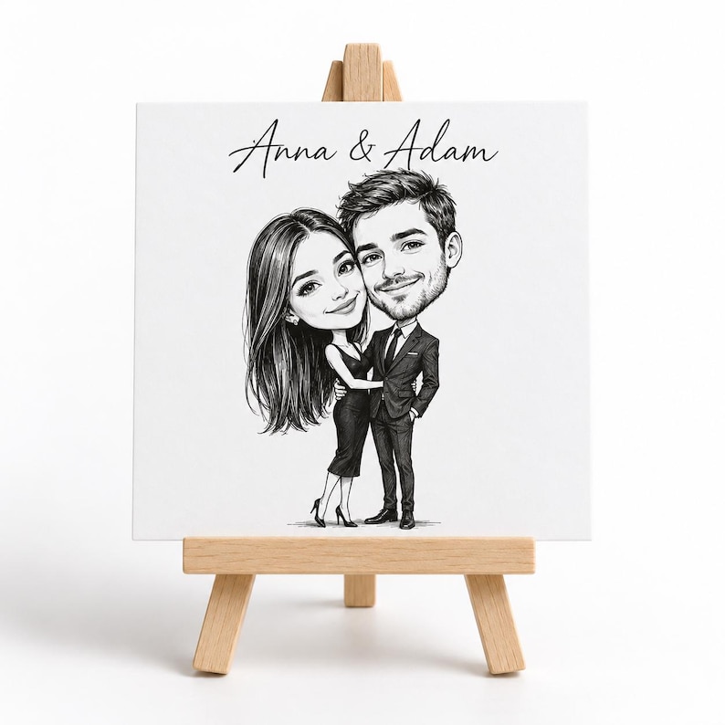 May include: A black and white caricature illustration of a couple standing together on a square white card displayed on a small wooden easel. The text Anna & Adam is printed in black script above the figures, who are dressed in formal attire.