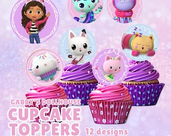 May include: A set of Gabby's Dollhouse cupcake toppers featuring 12 designs with various cartoon cat characters and a girl with cat ears. The circular toppers are displayed above cupcakes with pink frosting in purple floral patterned wrappers.