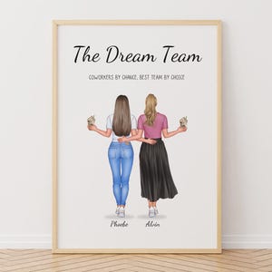 Puede incluir: Una impresión enmarcada con dos figuras, de espaldas, sosteniendo bebidas. El texto "The Dream Team" está encima de las figuras, con el texto "Coworkers by chance, Best team by choice" debajo. Las figuras se llaman Phoebe y Alain.