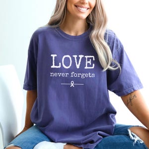 Maglietta per la sensibilizzazione sull&#39;Alzheimer &quot;Love Never Forgets&quot;, maglietta viola per l&#39;Alzheimer, regalo con nastro viola per il supporto all&#39;Alzheimer, maglietta per il supporto alla famiglia con demenza
