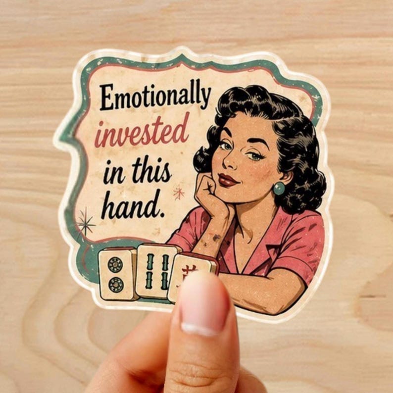 Może przedstawiać: Naklejka w stylu retro z ilustracją w stylu vintage kobiety i napisem "Emotionally invested in this hand". Kobieta ma na sobie r&oacute;żowy top i czarne włosy. Naklejka zawiera kafelki do mahjonga.