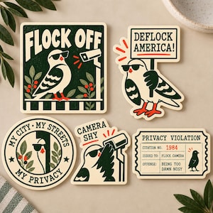 May include: A set of five stickers featuring illustrations of pigeons wearing sunglasses. Designs include a pigeon near a security camera with the text FLOCK OFF, a pigeon holding a DEFLOCK AMERICA sign, a circular sticker with MY CITY MY STREETS MY PRIVACY, a CAMERA SHY pigeon, and a PRIVACY VIOLATION citation ticket.