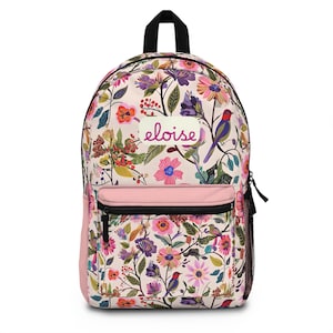 May include: A floral backpack with a pink pocket and the name "eloise" in cursive. The backpack features a colorful pattern of flowers, birds, and foliage on a cream background. It has a black zipper and a black handle.